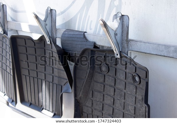 Dirty black car\
floor mats are prepared for cleaning with water. Washing of car\
mats. Cleaning of car wash\
mats