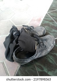 Dirty Black Shoes And Socks On The Floor