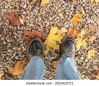 Dirty Boots Over Autumn Yellow Leaves Top View