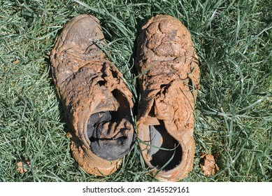 Dirty Boots And Socks In Mud And Clay On Green Grass Outdoors. Close-up, Top View, No People.