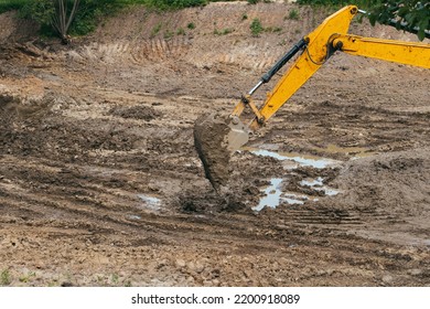 Dirty Bucket Of Excavator Digging Wet Soil.