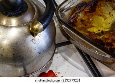 A Dirty Burner Gas Stove In The Kitchen. Dirty Kettle, Saucepan, Glass Baking Dish, Frying Pan