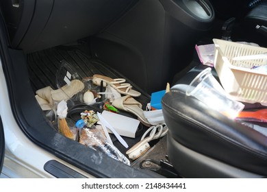 dirty car interior , carpet on the footwell has trash,food waste, dirt spilled across it. Needs to be cleaned and vacuumed inside . car maintenance concept