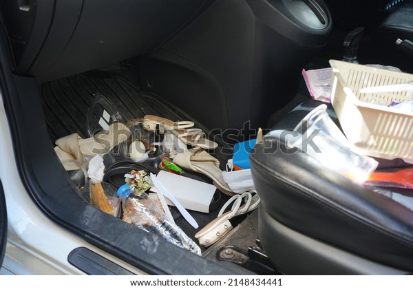 dirty car interior , carpet on the\
footwell has trash,food waste, dirt spilled across it. Needs to be\
cleaned and vacuumed inside . car maintenance\
concept