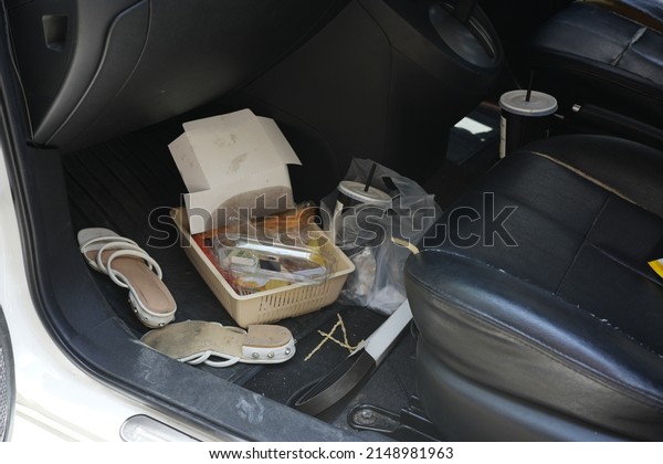 dirty car interior , carpet on the\
footwell has trash,food waste, dirt spilled across it. Needs to be\
cleaned and vacuumed inside . car maintenance\
concept
