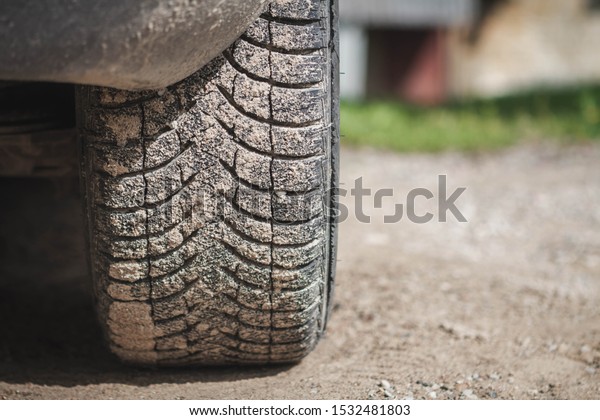 Dirty car tire after traveling. Closeup photo of
car wheel.