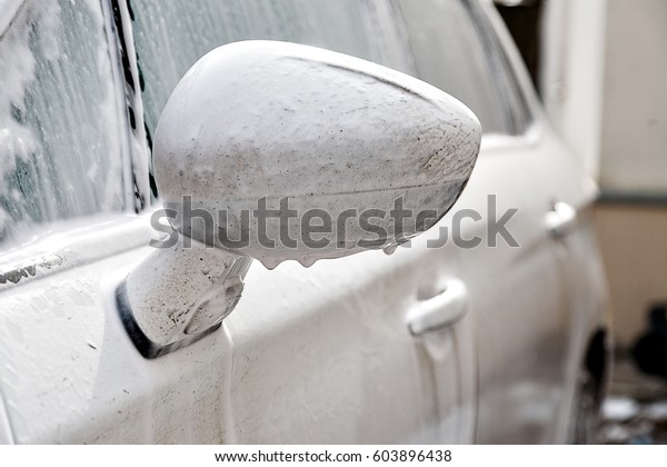 \
 Dirty car wash high pressure\
water. Car shampoo, foam, no contact car wash. White\
car