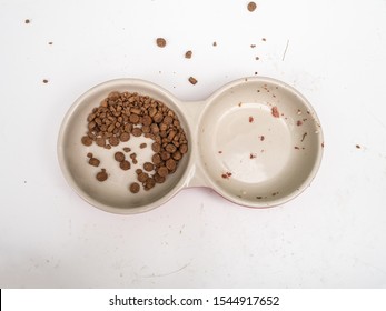 Dirty cat food bowls on a mucky white surface