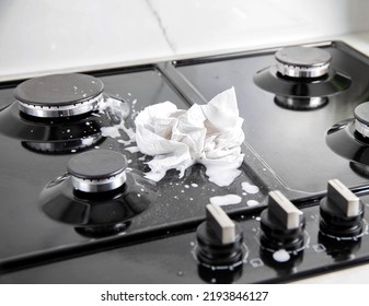 A Dirty Cloth With A Cleaning Agent Lies On A Gas Hob. Care And Cleaning Of Grease On A Gas Stove.