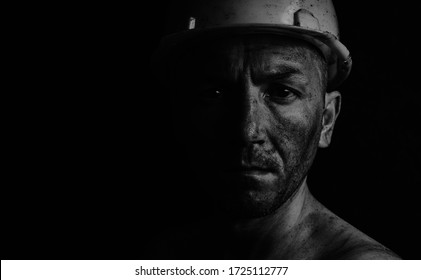 Dirty Coal Miner In A Yellow Hard Hat On A Dark Background In A Black And White Photo