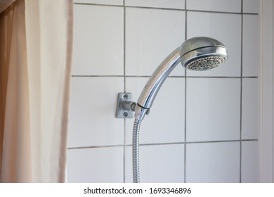 Dirty Corroded Limescale Calcified Shower Head Hanging From A Stand Inside Cabin Visible Curtain 2020