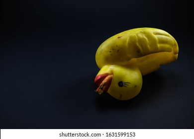 Dirty And Damaged Beak Yellow Rubber Duck Overturn Upside Down On Black Background Represents Road Isolated On Dark Blue Background, Space For Text.