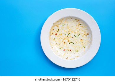 Dirty dish with unhappy face on blue background. Top view, Copy space