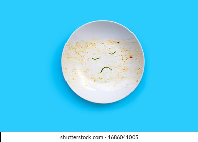 Dirty dish unhappy face on blue background. Top view, Copy space