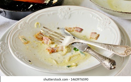 Dirty Dishes After Eating Pasta Carbonara. Bacon Sauce In A Plate
