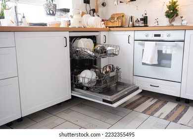 A lot of dirty dishes in the dishwasher. Helping the hostess, economy and ecology. Cleaning in the kitchen for the holidays of Christmas and New Year, after the feast and guests - Shutterstock ID 2232355495