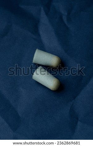 dirty earplugs in earwax close-up on a blue background