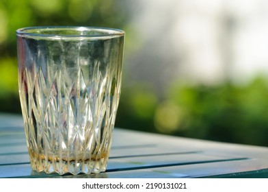 Dirty empty glass close-up in nature on a summer day. The concept of alcohol addiction, hangover, loneliness. Selective focus, bokeh with copy space - Shutterstock ID 2190131021
