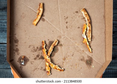 A Dirty And Empty Pizza Box. Leftover Fat And Food Waste Pizza Crusts.