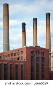 Dirty Factory Smoke Stacks Over An Old Brick Building