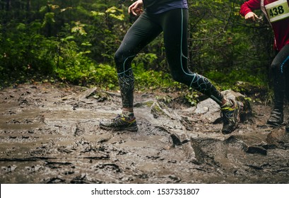 Dirty Feet Woman Runner Run Mountain Trail In Autumn Through Mud And Puddles