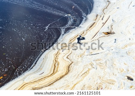dirty foam on the river. the problem of pollution of water bodies