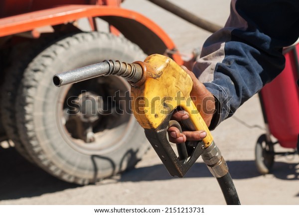 Dirty gas gun held by\
gas station worker