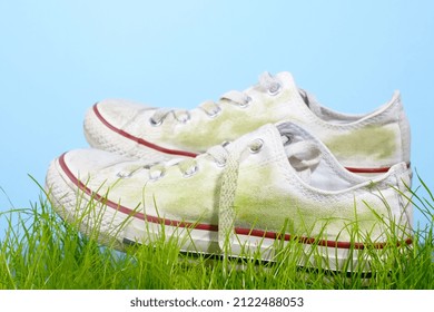 Dirty Grass Stains On White Sneakers. Daily Life Stain Concept. Close Up. Isolated On Blue Background. High Quality Photo
