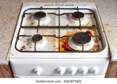 Dirty grease stove with food leftovers. Unclean gas kitchen cooktop with greasy spots, old fat stains, fry spots and oil splatters. - Shutterstock ID 2025873401