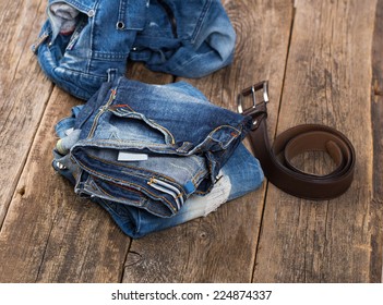 Dirty Jeans And Belt On Wooden Floor