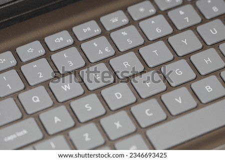 Dirty keyboard showing the letters QWERTY.  QWERTY keyboard.  Grey keys with dust in between.