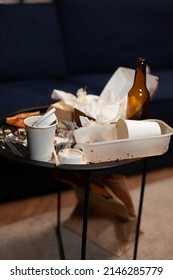 Dirty Leftovers Cans With Unfinished Food And Snacks On Table, Stinky And Unhealthy Garbage. Messy Space With Rubbish And Trash, Empty Beer Bottles Made By Unorganized Person. Close Up.