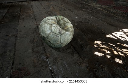 Dirty Loose Wind Soccer Ball Is On A Muddy Floor