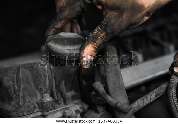 Dirty mechanic\
fixing car, closeup of\
hand