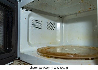 Dirty Microwave Oven. With Burnt Paint On The Walls And Traces Of Grease