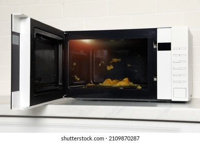 Dirty Microwave Oven On White Countertop Indoors