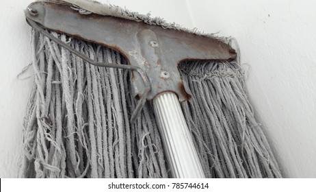 Dirty Mop On Dirty White Wall.