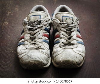 Dirty old shoes on wooden floor