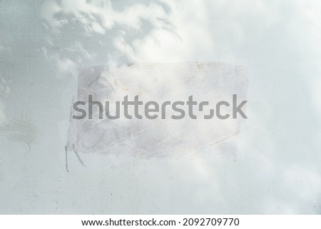 Dirty plastered wall with painted rectangular spot and shadow. Light texture, peeling plaster. Abstract background
