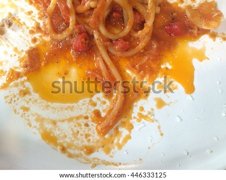 Dirty plate after eating spaghetti with spicy tomato sauce.