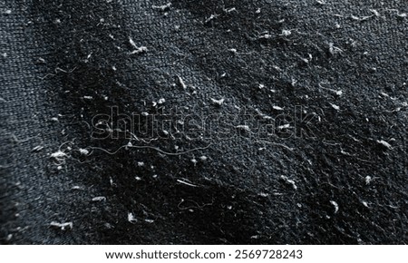 Dirty pulled threads clothes with pet hair. Rough and grunge background. Black fabric.