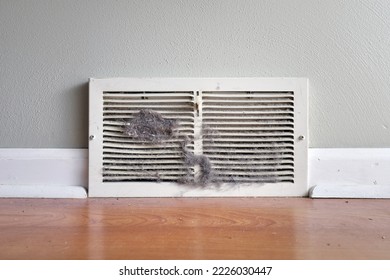 Dirty register wall vent with dust clogging the duct opening in a home  - Shutterstock ID 2226030447