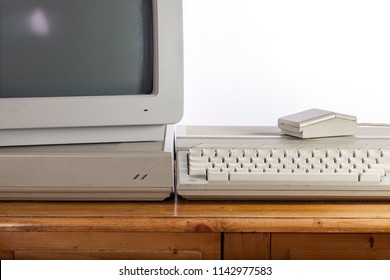 Dirty Retro Computer System On Old Pine Desk. Outdated Computing Technology. Vintage Eighties Personal Computer With Crt Monitor, Keyboard, Mouse And Hard Disc Drive.