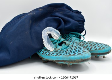 Dirty Rugby Gear On A White Background. Rugby Boots, Shorts And Gumshield Mouthguard