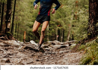 dirty runner athlete running down trail stones in woods