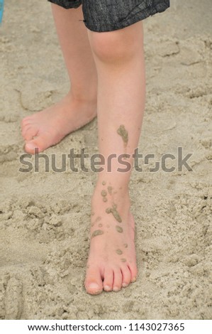 dirty sandy feets of a young boy at the beach