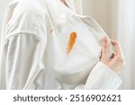 Dirty sauce stain cloth, asian young woman, girl wearing white shirt showing making on her cloth stain, spot dirty or smudge on clothes for cleaning before washing, maid female working at home concept