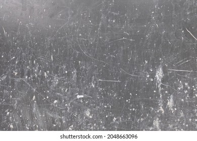 Dirty scratched gray wall with white paint splotches. Artsy background.