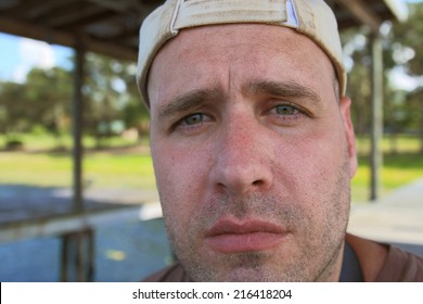 Dirty Scruffy Unshaven Burly Masculine Man Wearing Dirty Hat Outside Looking Depressed Disappointed Disbelieving Disgusted Emotional Incredulous Sad Uncertain Unhappy Worried Confused Concerned