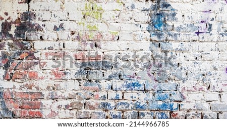 Dirty shabby painted brick surface, paints of different colors. Colorful grunge texture of wall close-up